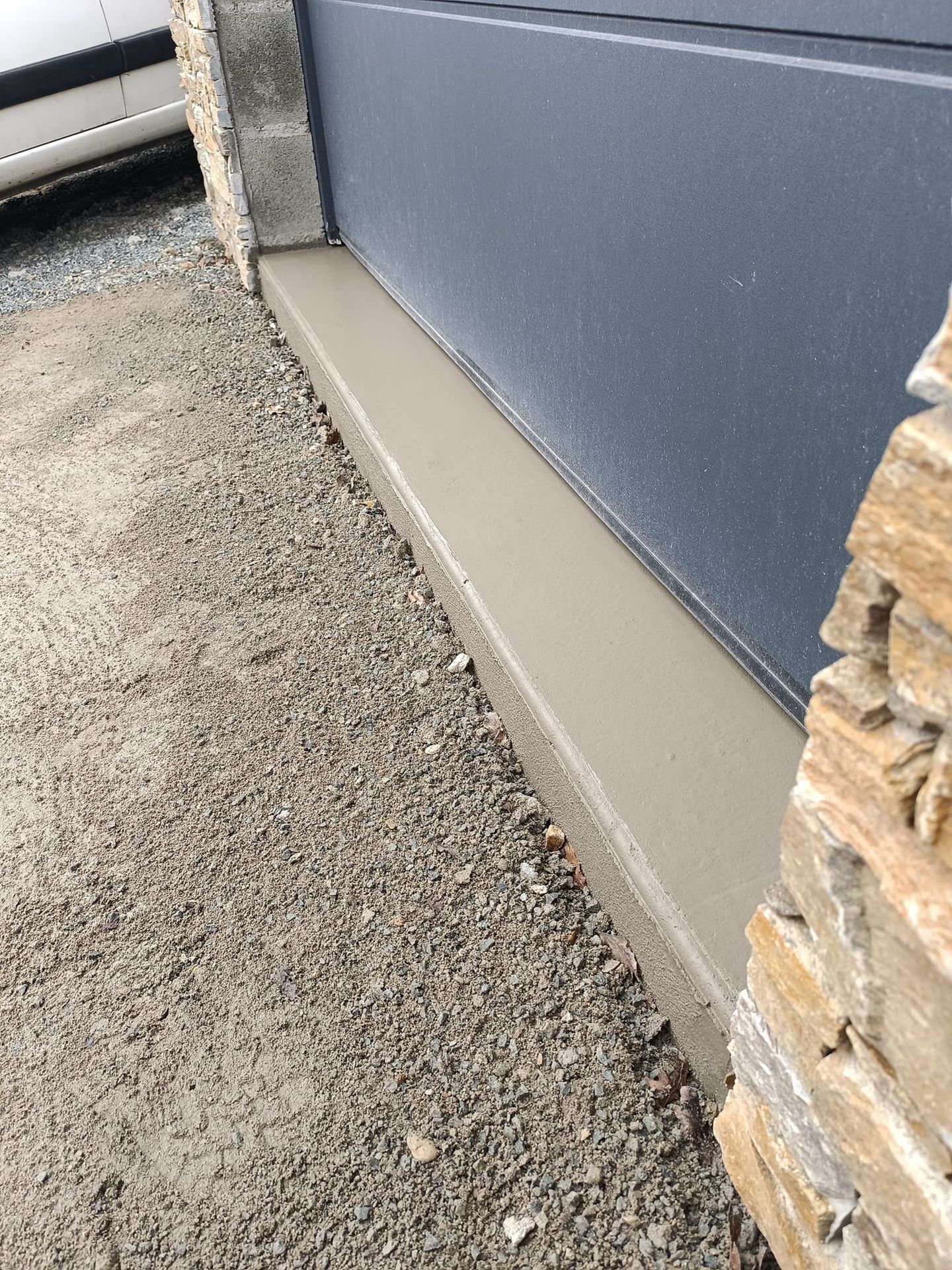 Finition du seuil de garage en béton devant porte de garage